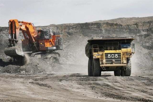 A haul truck carrying a full load drives away from a mining shovel at the Shell Albian Sands oilsands mine near Fort McMurray, Alta., Wednesday, July 9, 2008. THE CANADIAN PRESS/Jeff McIntosh