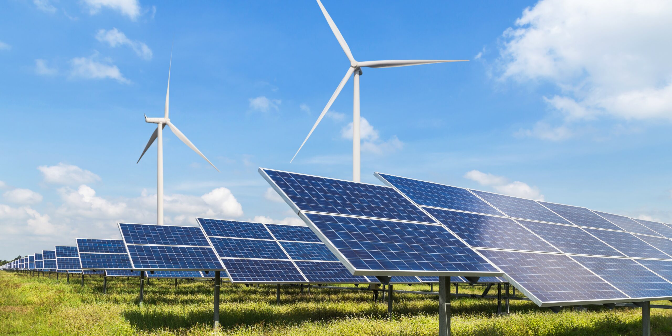 solar panels and wind turbines generating electricity in power station green energy renewable with blue sky background